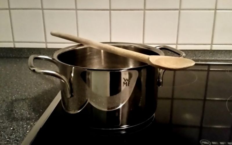 Einen Holzkochlöffel quer über den Topf mit kochendem Wasser legen