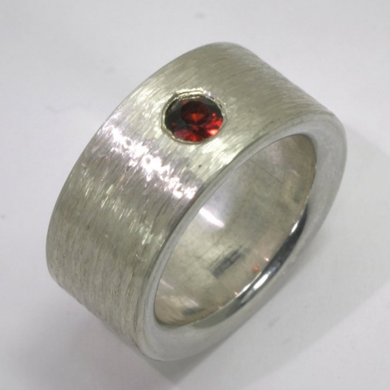 Dieser Ring aus 925- Silber mit rotem Granat weist eine lebendige längsgerichtete Oberfläche auf. - TRIMETALL Schmuck - Design - Objekte - Köln- Bild 1